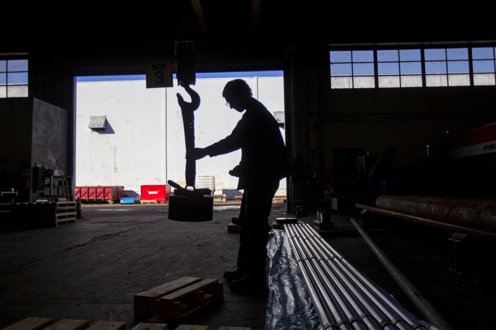 A sawyer uses a giant magnet to move a cut of machine grade steel at the Pacific Machinery & Tool Steel Company on March 6, 2018 in Portland, Oregon.  Natalie Behring/AFP
