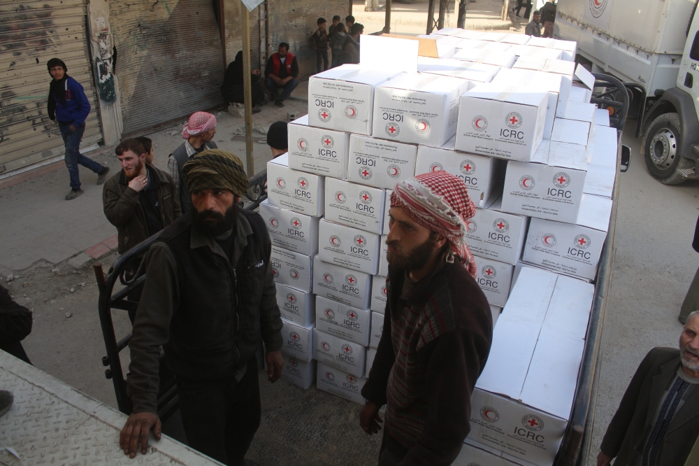 People organize the United Nations' aid boxes after United Nations' aid convoy enters the Douma town of Eastern Ghouta after Assad Regime stopped the assaults in Damascus, Syria on March 05, 2018. (Ammar Sab - Anadolu Agency)