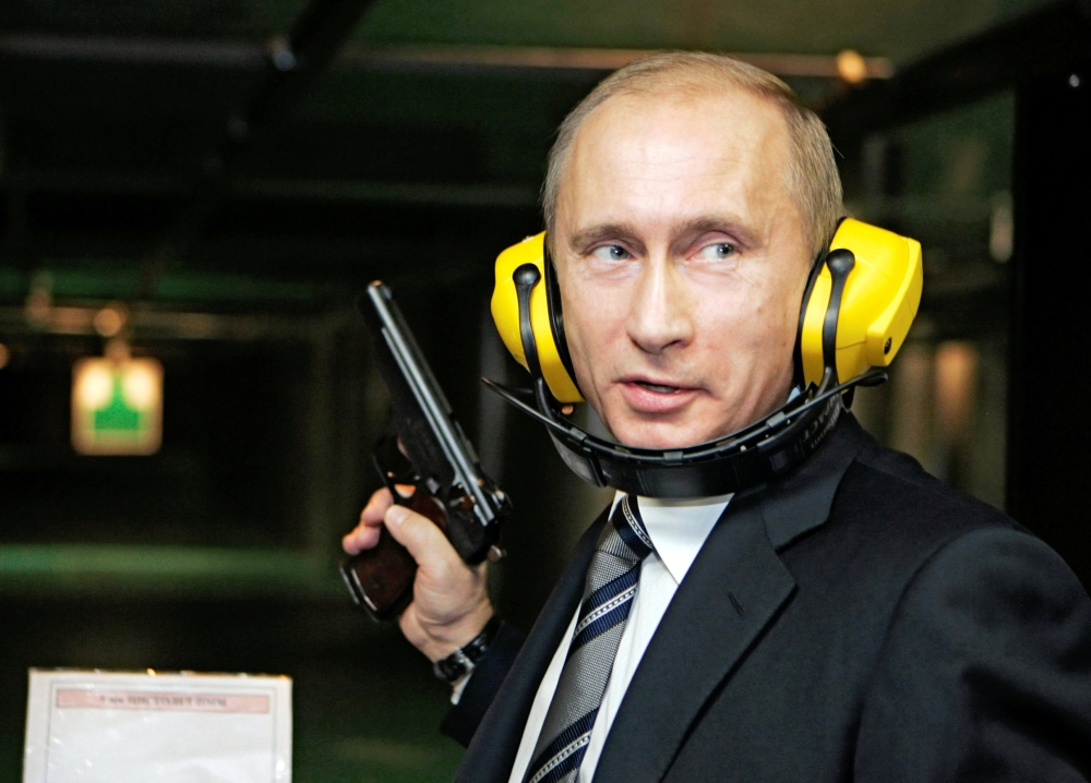 FILE PHOTO: Russian President Vladimir Putin stands with a gun at a shooting gallery of the new GRU military intelligence headquarters building as he visits it in Moscow November 8, 2006. REUTERS
