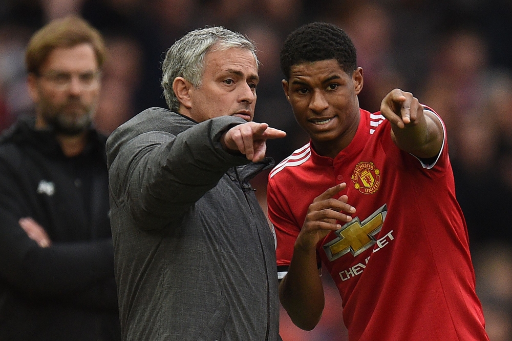 Liverpool's German manager Jurgen Klopp (L) watches as Manchester United's Portuguese manager Jose Mourinho (C) talks with Manchester United's English striker Marcus Rashford during the English Premier League football match between Manchester United and L