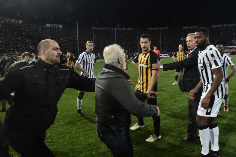Paok president Ivan Savvidis (C) takes to the pitch carrying a handgun in his waistband (below C), after the referee refused a last minute goal on March 11, 2018 during the Greek Superleague football match PAOK Thessaloniki vs AEK Athens on March 11, 2018