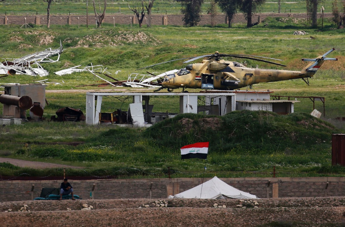 FILE PHOTO: An Iraqi army helicopter sits in a field on the outskirts of western Mosul on April 3, 2017 during an offensive to retake the city from Islamic State group fighters. (AFP / Ahmad Gharabli) 