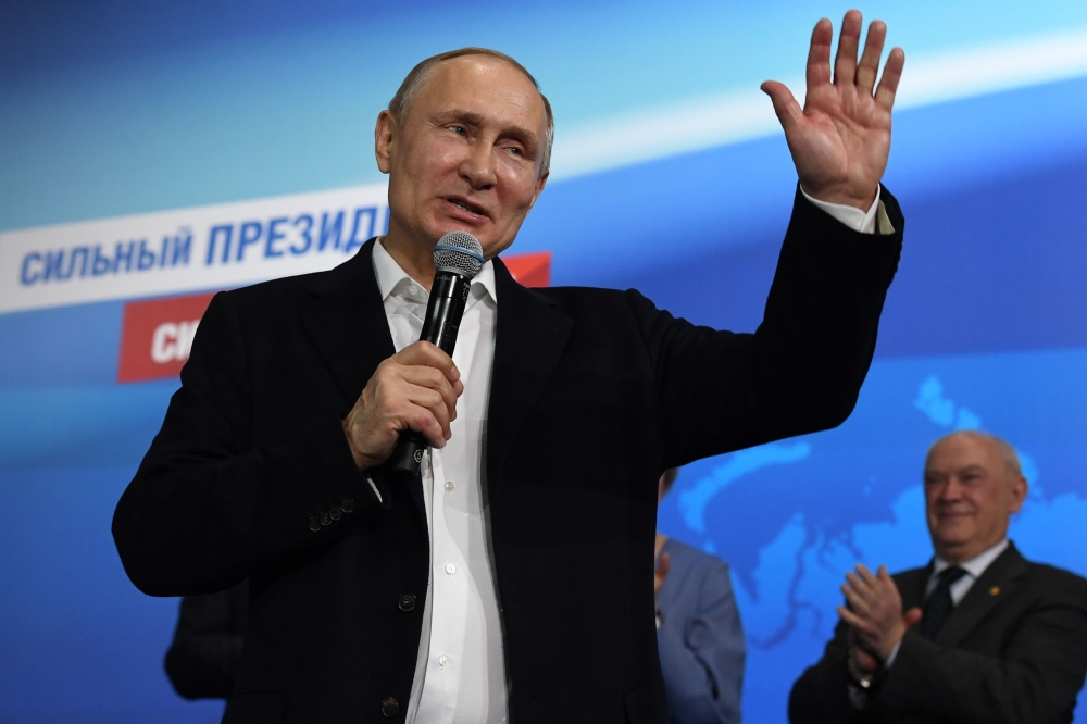 Presidential candidate, President Vladimir Putin speaks as he meets with confidants at his campaign headquarters in Moscow on March 18, 2018. / AFP / Yuri KADOBNOV
