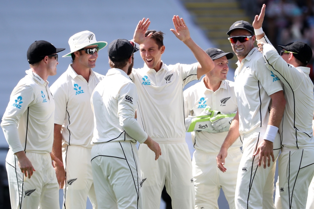 Trent Boult of New Zealand (C) celebrates a wicket during the first day of the day-night Test cricket match between New Zealand and England at Eden Park in Auckland on March 22, 2018. / AFP / Fiona Goodall