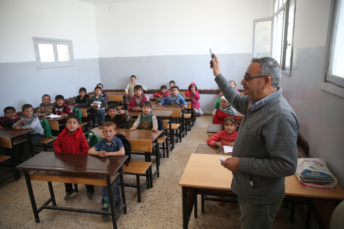 A teacher is seen with students during a lesson at a renovated school after it was damaged by YPG/PKK and Daesh terrorists within the 