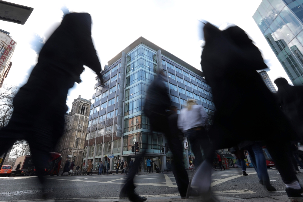 Pedestrians pass the shared building which houses the offices of Cambridge Analytica in central London on March 21, 2018.  AFP / Daniel Leal-Olivas