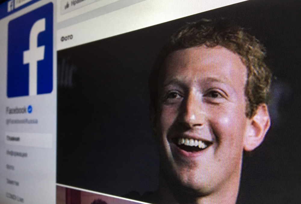 A picture taken in Moscow on March 22, 2018 shows an illustration picture of the Russian language version of Facebook about page featuring the face of founder and CEO Mark Zuckerberg.  AFP / Mladen Antonov