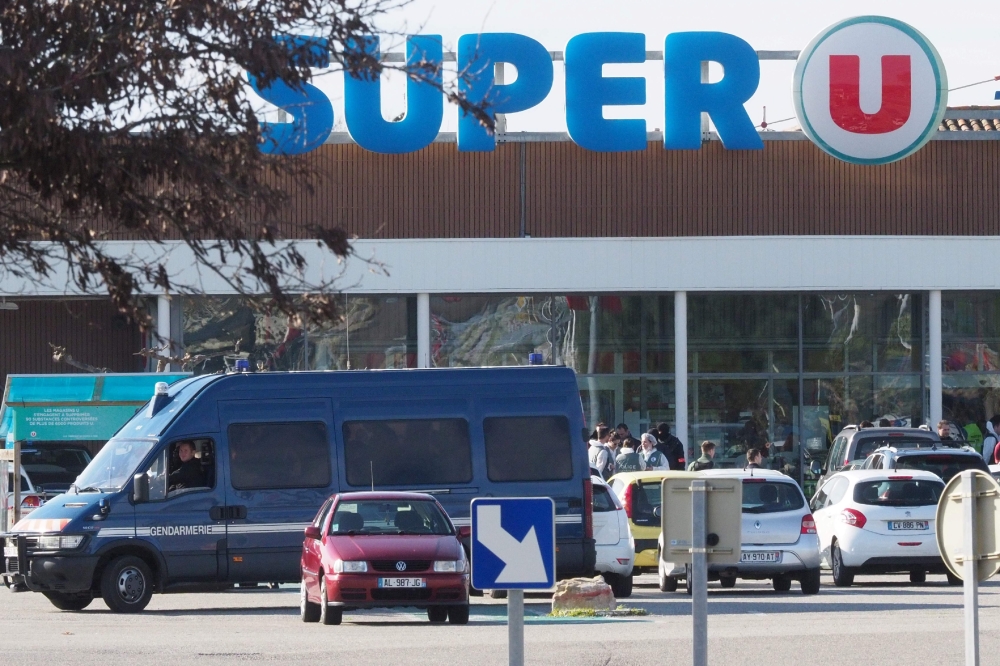 Policemen are at work outside the Super U supermarket of Trebes, southern France on March 23, 2018, after special forces killed a gunman who had taken several people hostages for more than three hours. AFP / Raymond Roig 