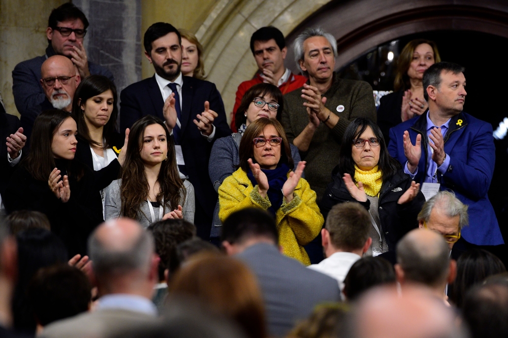 Family members of jailed Catalan leaders including Meritxell Lluis (back C), wife of Josep Rull, Diana Riba (C-R), wife of Raul Romeva, and Blanca Bragulat (C), wife of Jordi Turull, along with their daughters (L) applaud at the end of a parliament sessio