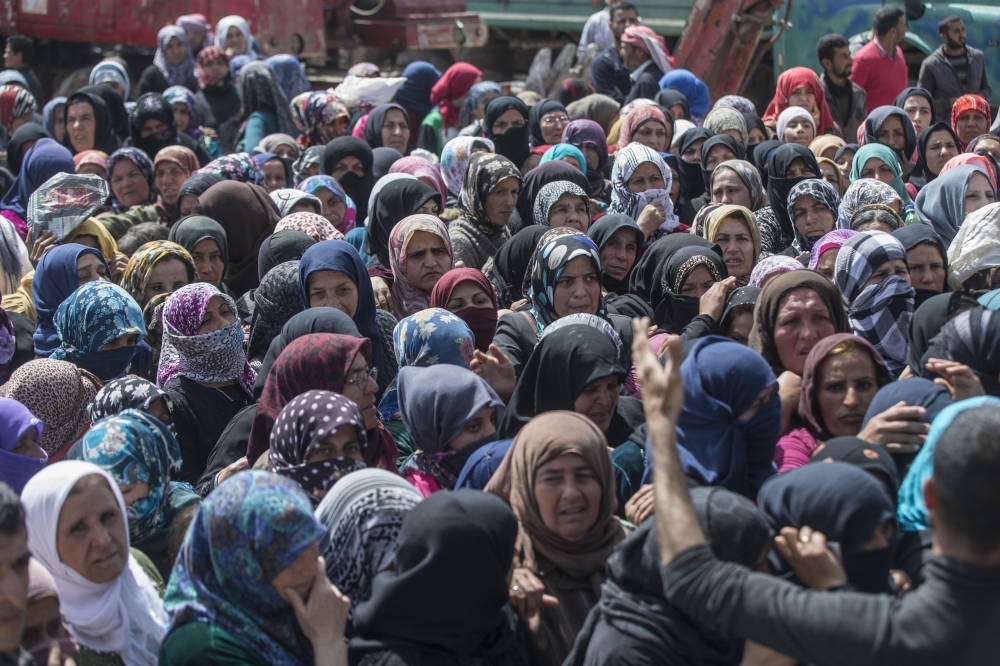 People wait to receive the food and hygiene packages distributed by Turkey's Disaster Management Agency (AFAD) in Afrin, Syria after Turkish Armed Forces and Free Syrian Army (FSA) took complete control of northwestern Syria's Afrin within the 