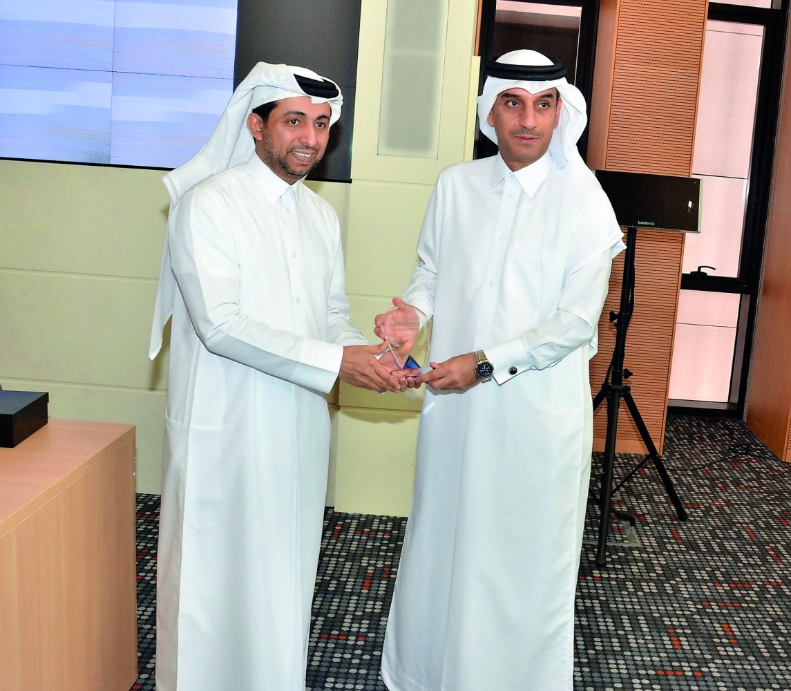 Jamal Abdullah Al Jamal (right), QIIB Deputy CEO; receiving a shield from Dr Hassan Al Derham, President of Qatar University.