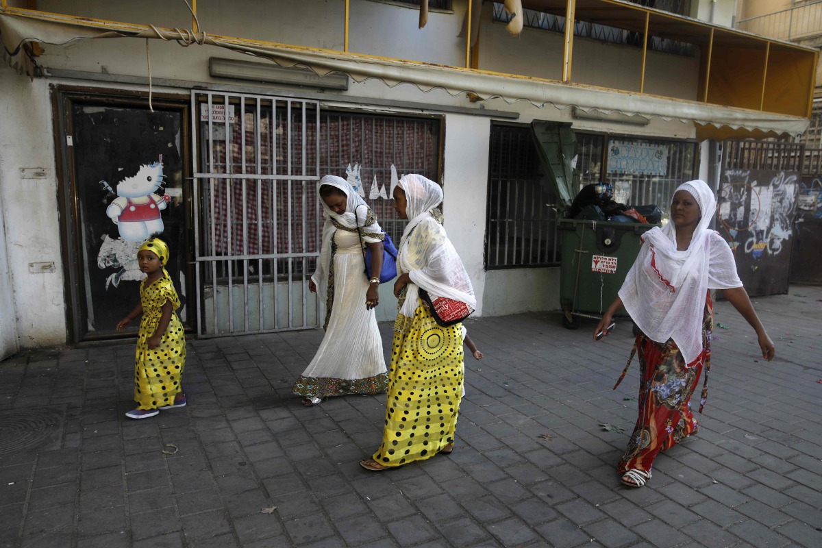 This file photo taken on September 2, 2017 shows Christian African Eritrean migrants walking outside at a makeshift church in southern Tel Aviv. (AFP / Menahem Kahana) 