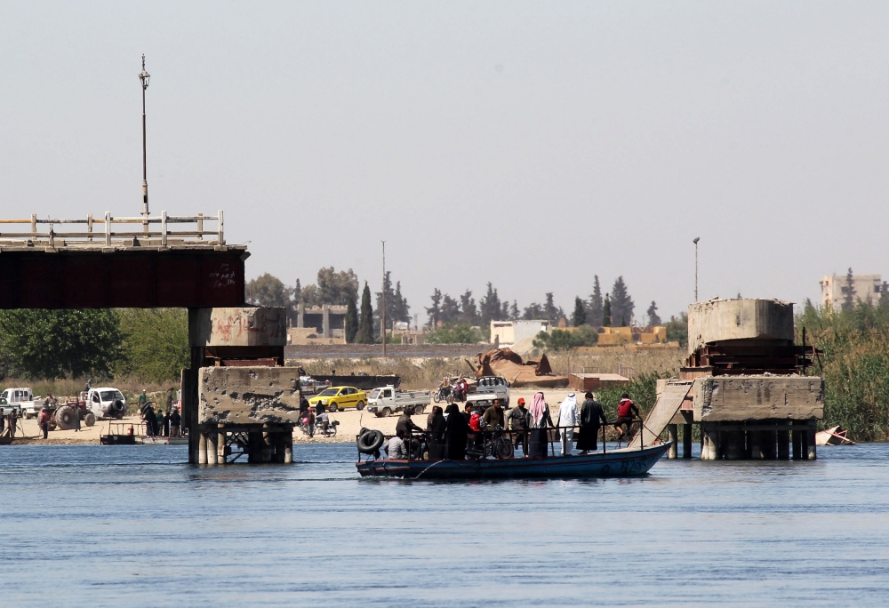 People cross the Euphrates River on a boat in Raqqa, Syria April 5, 2018.REUTERS/Aboud Hamam
