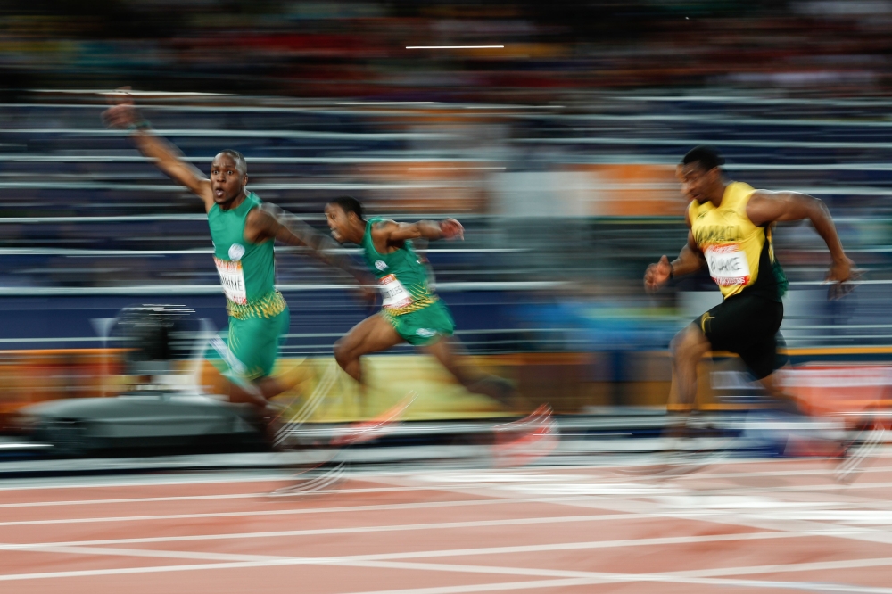 South Africa's Akani Simbine celebrates as he wins the gold medal ahead of South Africa's Henricho Bruintjies (C) and Jamaica's Yohan Blake in the athletics men's 100m final during the 2018 Gold Coast Commonwealth Games at the Carrara Stadium on the Gold 