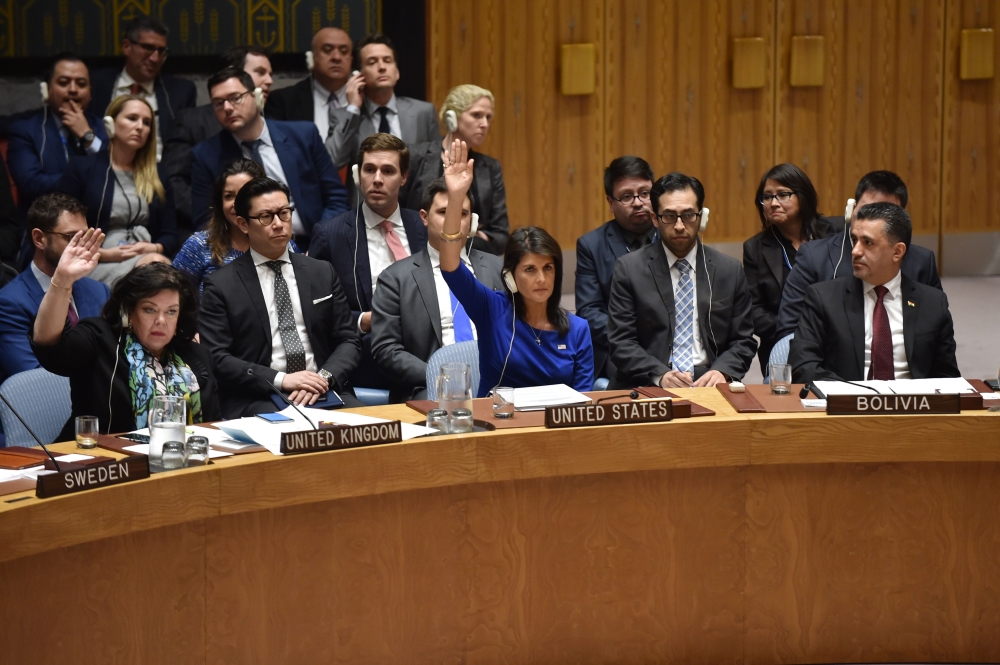  British Ambassador to the UN Karen Pierce (L) and US Ambassador to the UN Nikki Haley (C) vote during a UN Security Council meeting, at the United Nations Headquarters in New York, on April 14, 2018. / AFP / HECTOR RETAMAL 