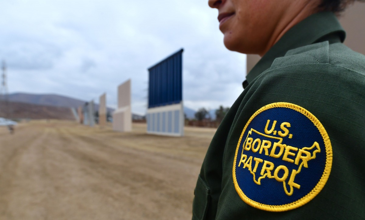 US Border Patrol officer Tekae Michael stands near prototypes of border wall proposed by US President Donald Trump on November 1, 2017 in San Diego, California (AFP / Frederic J Brown) 