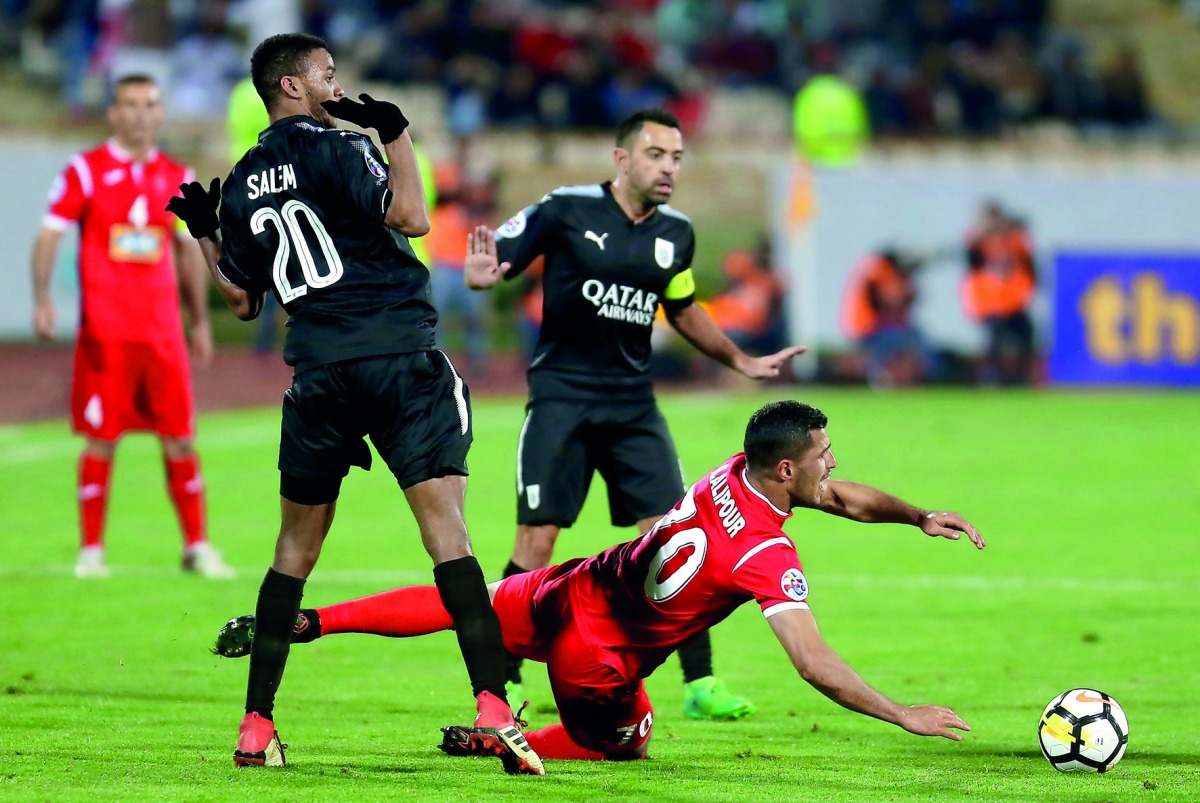 Al Sadd’s Xavier Hernandez (centre) and Salem Ali Al-Hajri (left) react as Persepolis’ Ali Alipour falls to the ground during the AFC Champions League match  at the Azadi Stadium in Tehran on Monday.