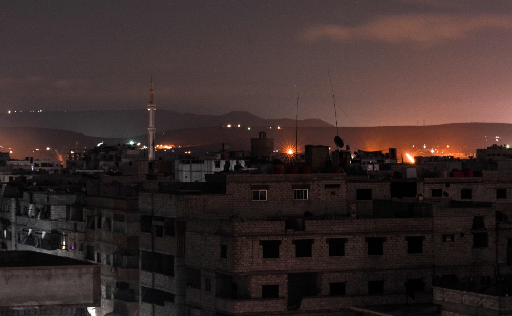 A picture taken early on April 21, 2018 shows explosions appearing in the skyline of a southern district of the Syrian capital Damascus, during regime strikes targeting the Islamic State group in the Palestinian camp of Yarmouk, and neighbouring districts