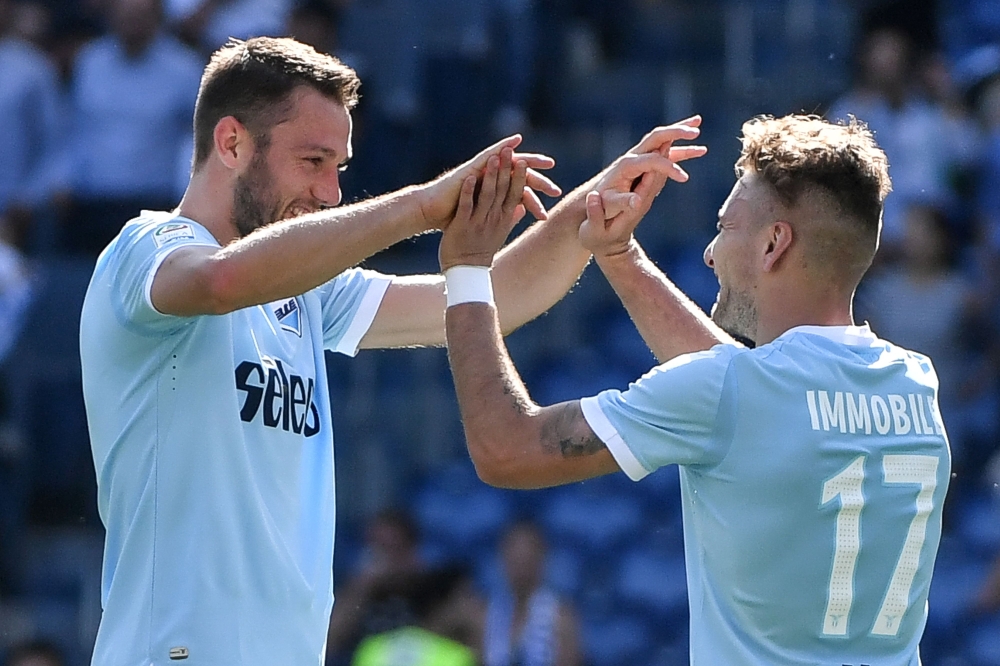 Lazio's Italian midfielder Ciro Immobile (R) celebrates with Lazio's Dutch defender Stefan de Vrij after scoring a goal during the Italian Serie A football match Lazio versus Sampdoria on April 22, 2018 at Rome's Olympic Stadium. / AFP / Andreas SOLARO
