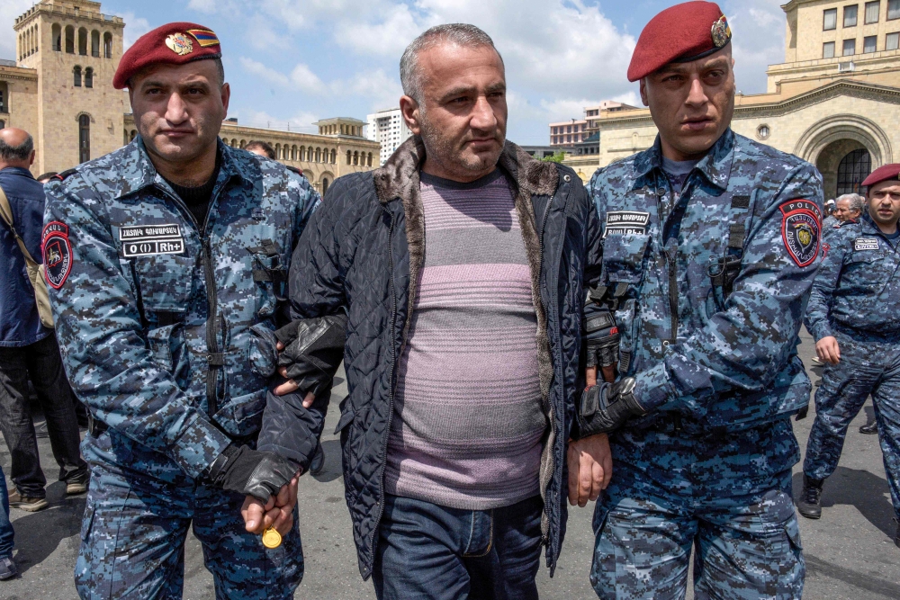 Armenian special police forces detain an opposition supporter during a demonstration called by opposition, held to protest former president's election as prime minister in central Yerevan on April 22, 2018.  AFP / Karen Minasyan

