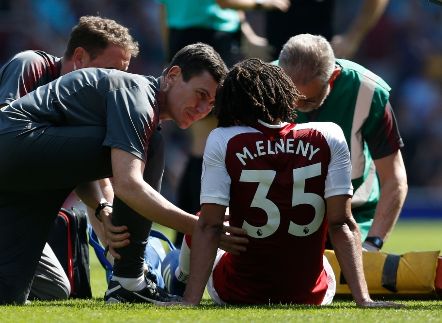 Arsenal's Egyptian midfielder Mohamed Elneny gets attention for an injury before being stretchered off during the English Premier League football match between Arsenal and West Ham United at the Emirates Stadium in London on April 22, 2018.   AFP / Ian KI