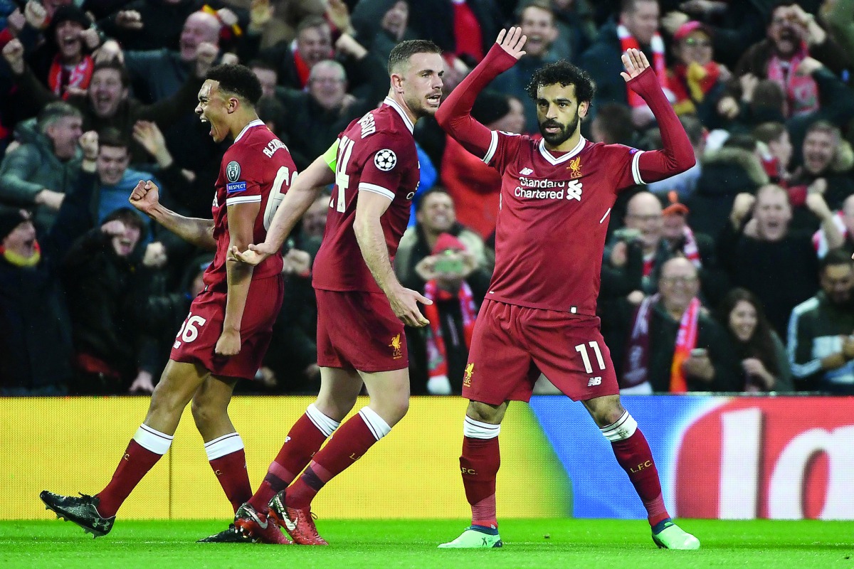 Liverpool's Egyptian midfielder Mohamed Salah (R) celebrates scoring their first goal during the UEFA Champions League first leg semi-final football match between Liverpool and Roma at Anfield stadium in Liverpool, north west England on April 24, 2018. AF