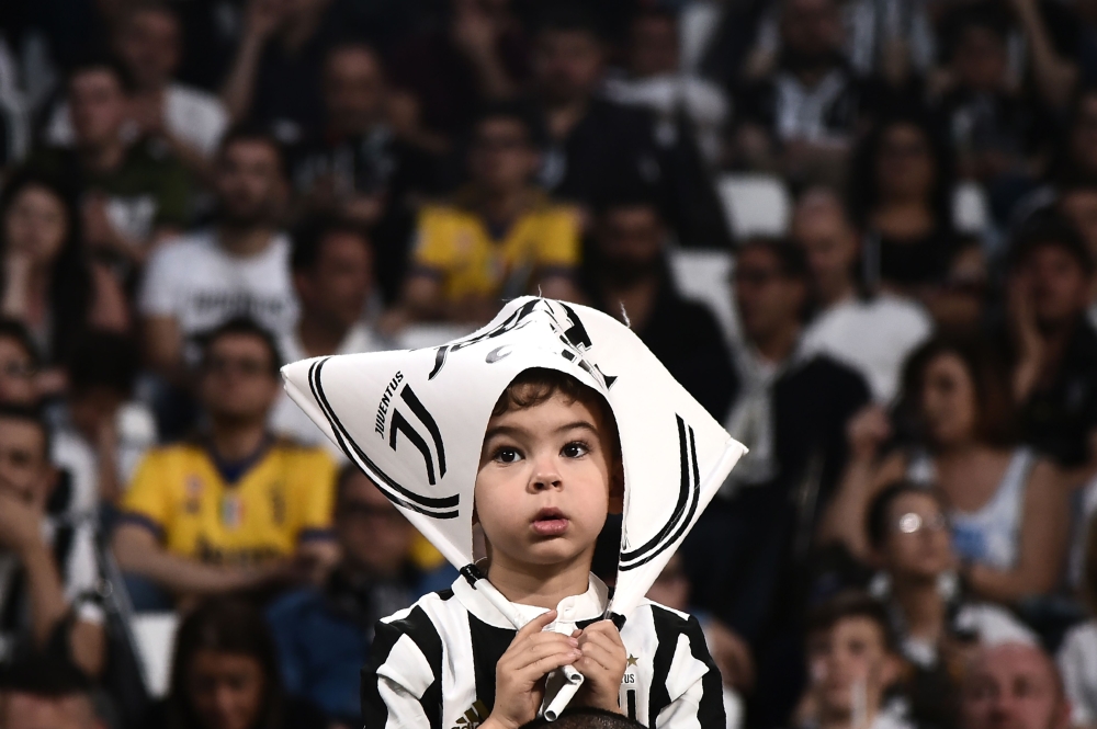 A young Juventus'supporter looks on during the Italian Serie A football match between Juventus and Napoli on April 22, 2018 at the Allianz Stadium in Turin. / AFP / MARCO BERTORELLO

