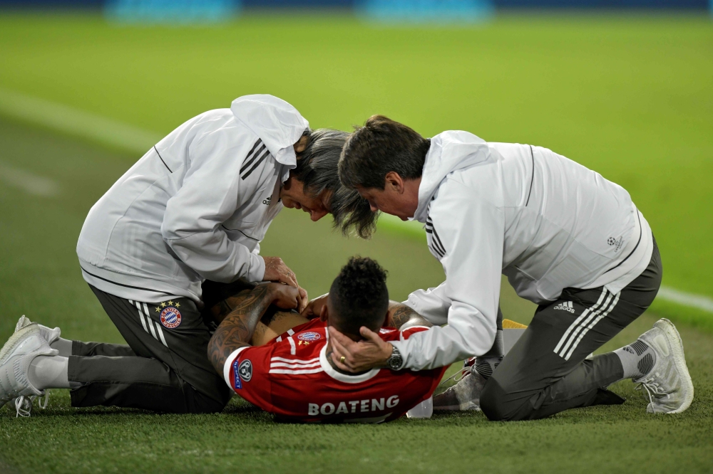 Bayern Munich's German defender Jerome Boateng receives medical care after being injured during the UEFA Champions League semi-final first-leg football match FC Bayern Munich v Real Madrid CF in Munich, southern Germany on April 25, 2018. / AFP / GUENTER 
