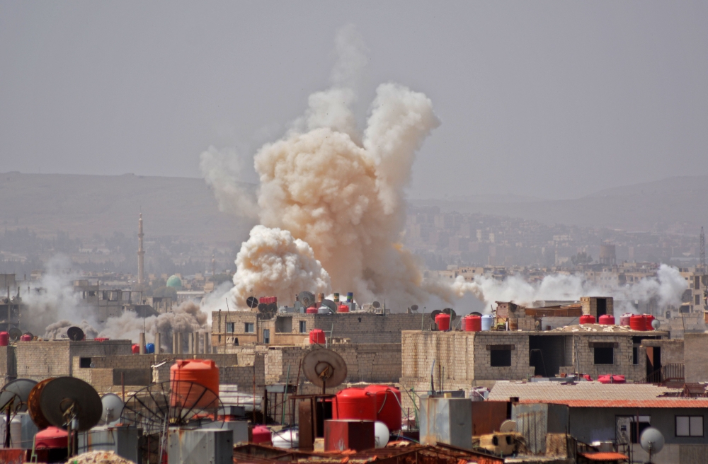 A picture taken in the Yarmuk Palestinian refugee camp in southern Damascus on April 27, 2018 shows smoke billowing in the area during Syrian army shelling and airstrikes.  AFP / Rami al SAYED