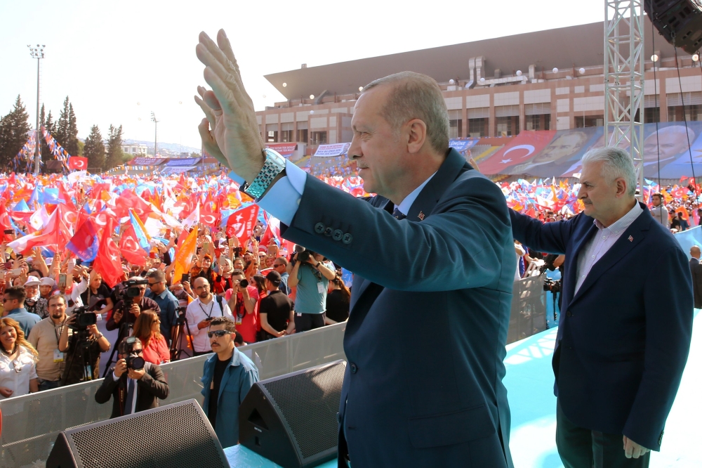 Turkish President Recep Tayyip Erdogan (L) and Turkish Prime Minister Binali Yildirim greet the crowd after attending AK Party's 6th ordinary provincial congress in western Izmir province, Turkey on April 28, 2018. AFP PHOTO / TURKISH PRESIDENTIAL PRESS S