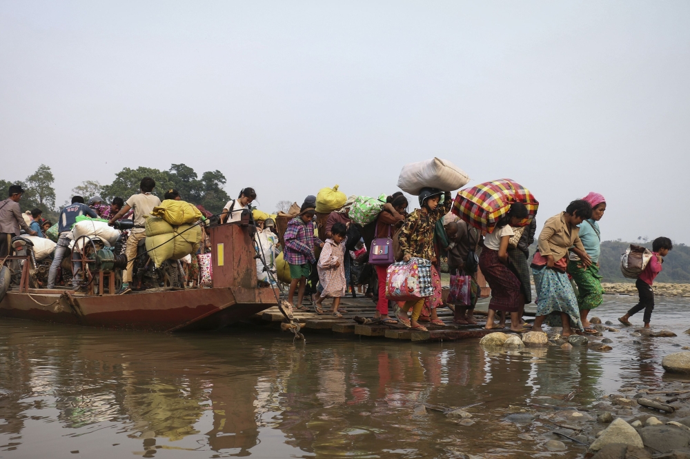 This picture taken on April 26, 2018 shows displaced Kachin residents crossing Malikha river on a ferry to escape the fighting in Injanyan village near Myitkyina between the Kachin Independence Army, ethnic armed group against the Myanmar government troop