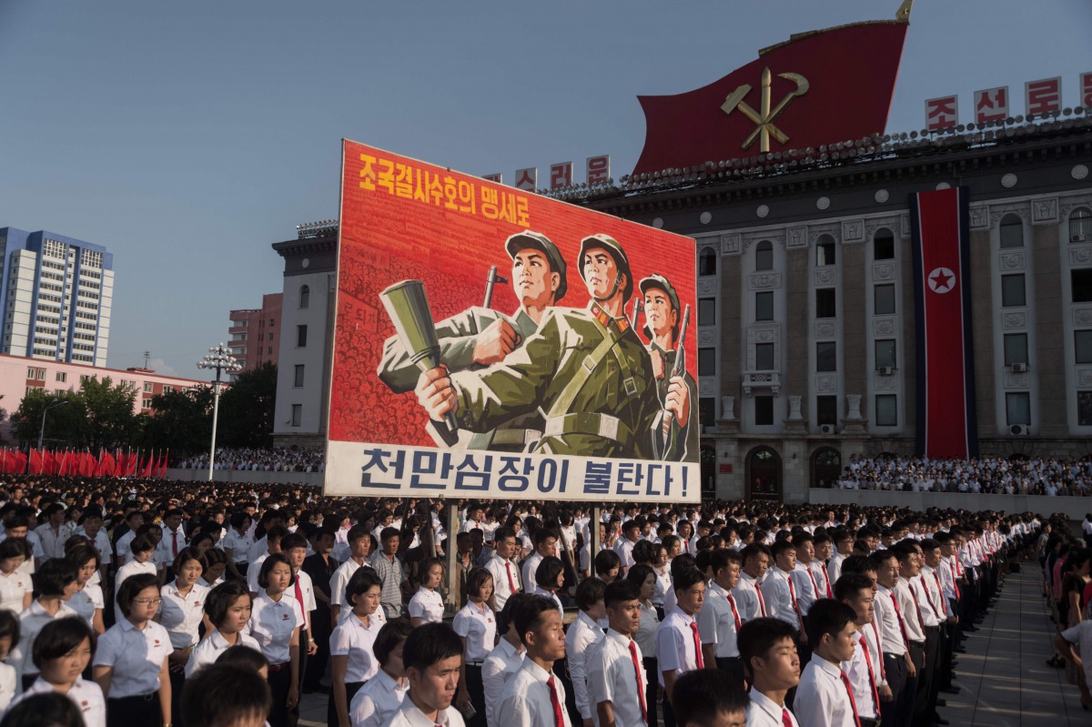 FILE PHOTO: People wave banners and shout slogans as they attend a rally in support of North Korean stance against the US on Kim Il-Sung square in Pyongyang on August 9, 2017 (AFP / Kim Won-Jin) 