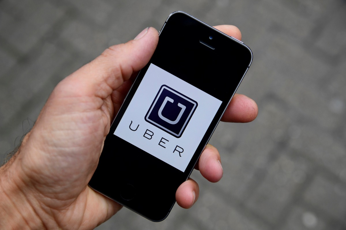 A photo illustration shows the Uber app logo displayed on a mobile telephone as it is held up for a posed photograph in central London, October 28, 2016. (Reuters / Toby Melville)