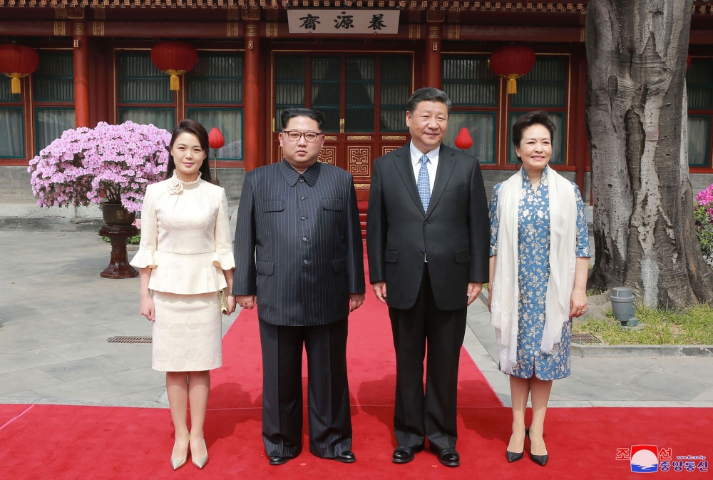 China President Xi Jinping his wife Peng Liyuan North Korean leader Kim Jong Un and his wife Ri Sol Ju posing for a picture in Beijing on March 27 2018 AFP KCNA via KNS