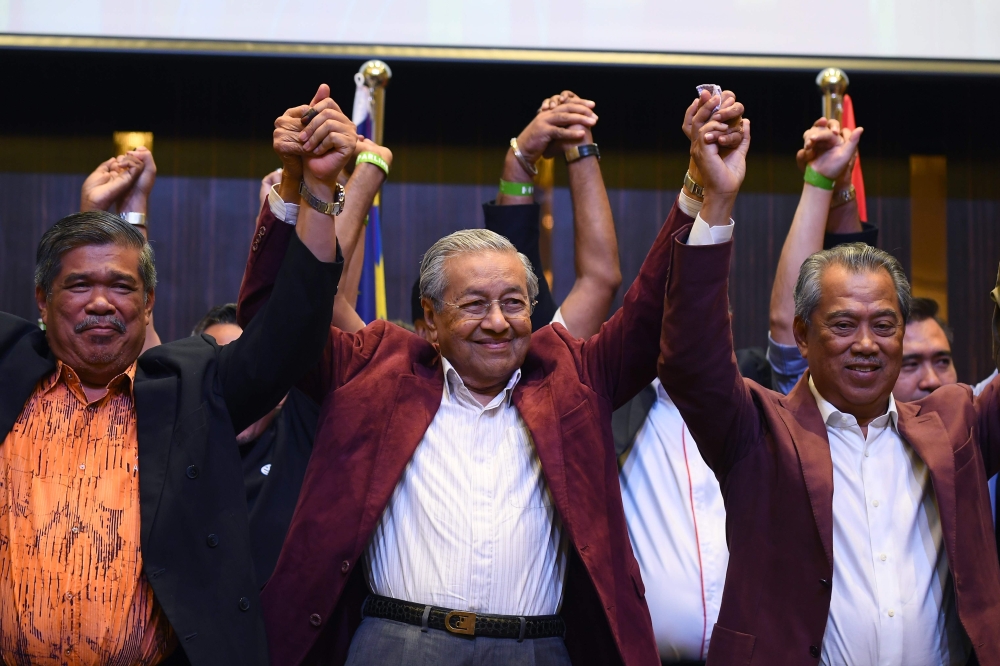 Former Malaysian prime minister and opposition candidate Mahathir Mohamad (C) celebrates with other leaders of his coalition during a press conference following the 14th general elections in Kuala Lumpur on early May 10, 2018. AFP / Manan Vatsyayana 