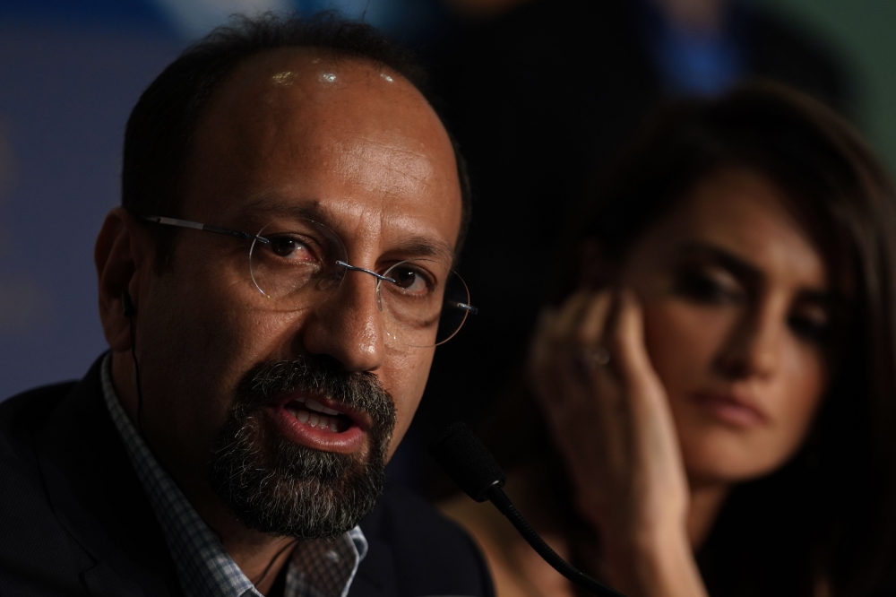 Iranian director Asghar Farhadi (L) speaks as Spanish actress Penelope Cruz listens during a press conference for the film 