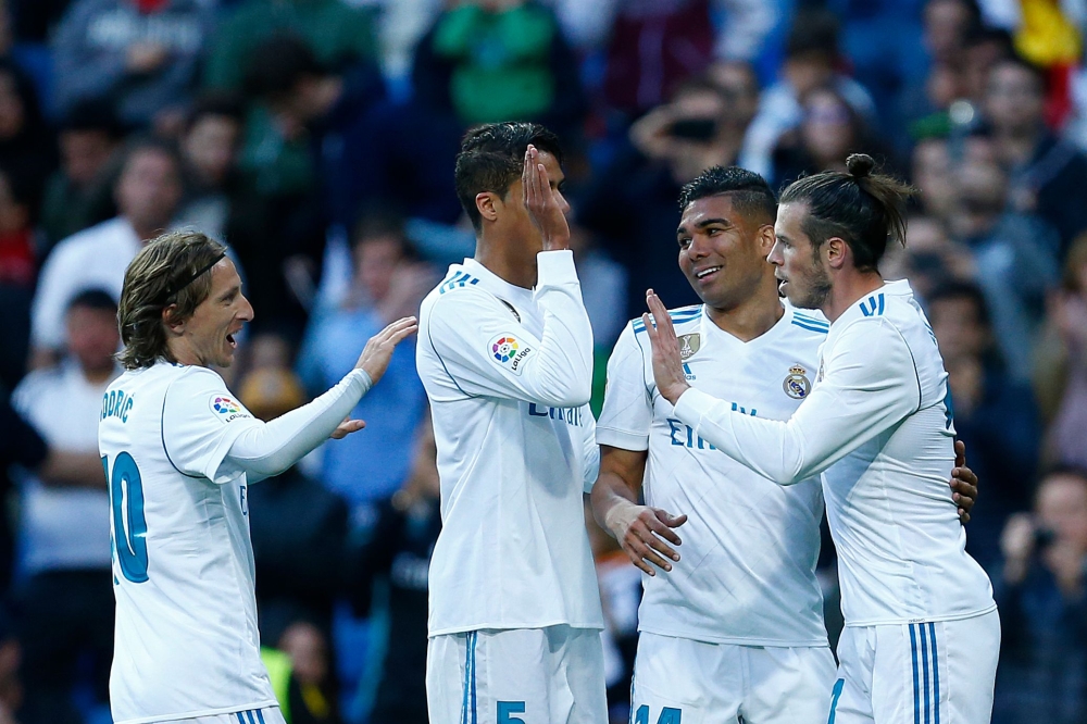 Real Madrid's Welsh forward Gareth Bale (R) celebrates a goal with teammates during the Spanish league football match between Real Madrid and Celta Vigo at the Santiago Bernabeu stadium in Madrid on May 12, 2018. / AFP / Benjamin CREMEL