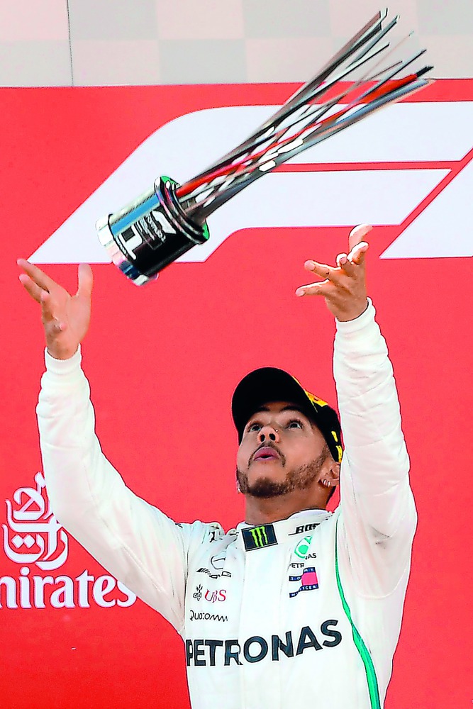 Mercedes' British driver and first place winner Lewis Hamilton celebrates on the podium after the Spanish Formula One Grand Prix at the Circuit de Catalunya in Montmelo in the outskirts of Barcelona on May 13, 2018. AFP / Lluis Gene