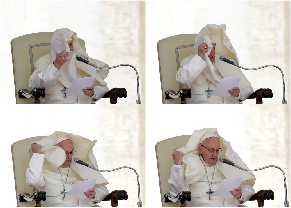 A combination photo shows a gust of wind blowing Pope Francis' mantle during the Wednesday general audience in Saint Peter's square at the Vatican, May 16, 2018. Reuters/Max Rossi