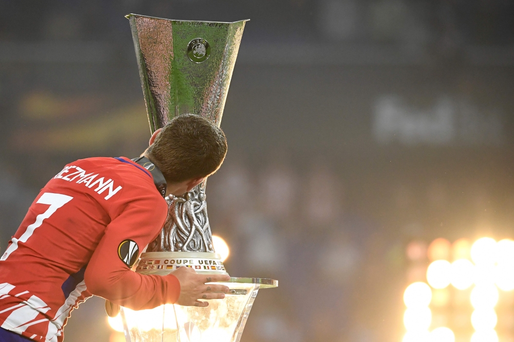 Atletico Madrid's French forward Antoine Griezmann kisses the trophy after the UEFA Europa League final football match between Olympique de Marseille and Club Atletico de Madrid at the Parc OL stadium in Decines-Charpieu, near Lyon on May 16, 2018. AFP / 