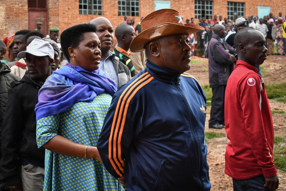 Burundi's President Pierre Nkurunziza (2R) waits with his wife Denise (3R) as they queue to cast their votes for the referendum on a controversial constitutional reform in Buye, northern Burundi, on May 17, 2018.  AFP / STR
