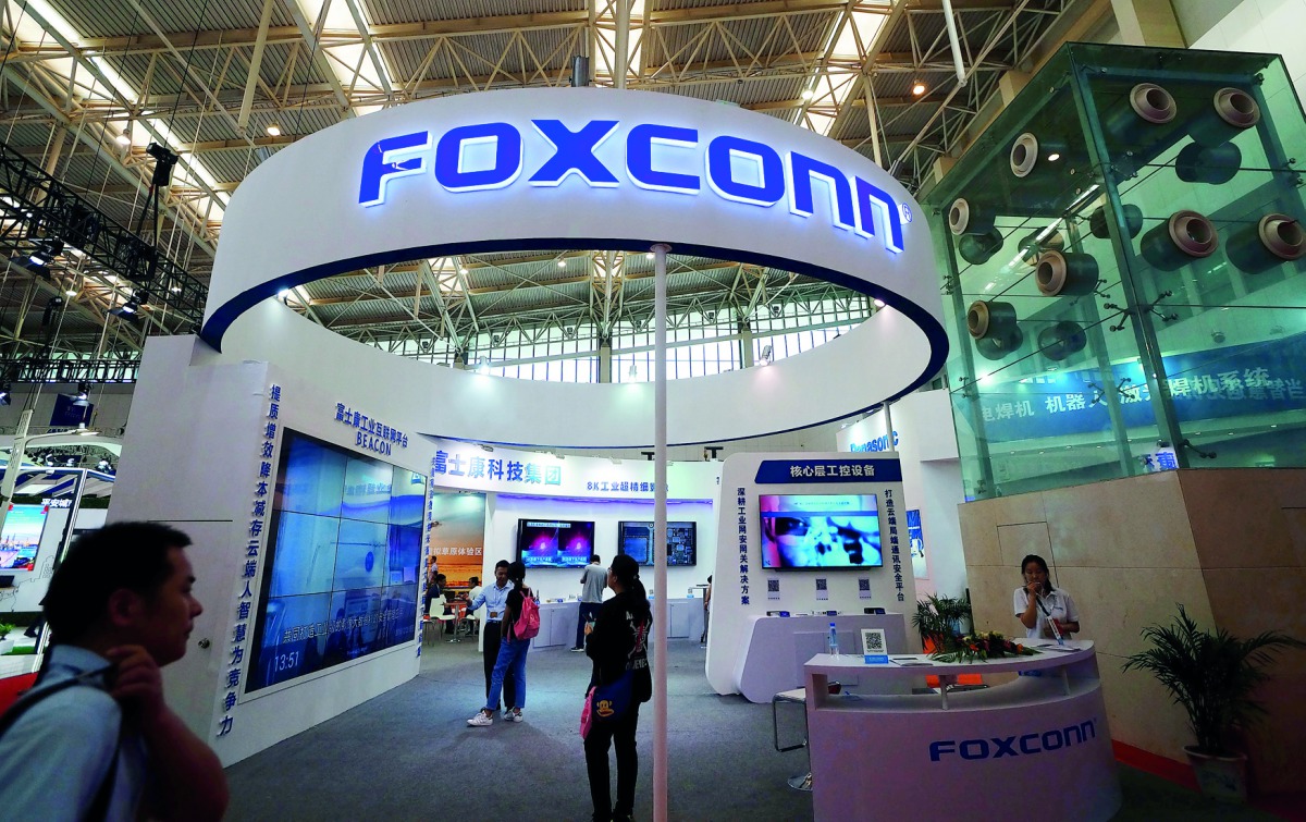 Visitors are seen at a Foxconn booth at the World Intelligence Congress in Tianjin, China May 19, 2018. Picture taken May 19, 2018. Reuters/Stringer