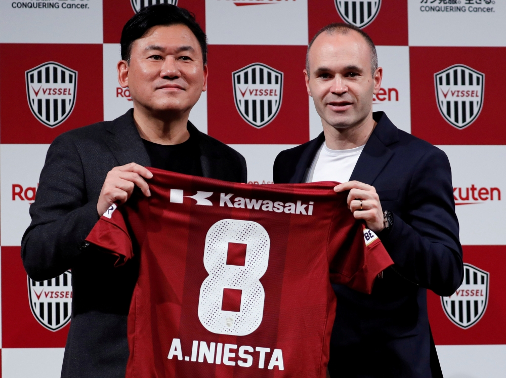 Spain midfielder Andres Iniesta and Hiroshi Mikitani, Chairman and CEO of Rakuten Inc and the owner of Vissel Kobe, pose with Iniesta's new team jersey at a news conference to announce signing for J-League side Vissel Kobe in Tokyo, Japan May 24, 2018. RE