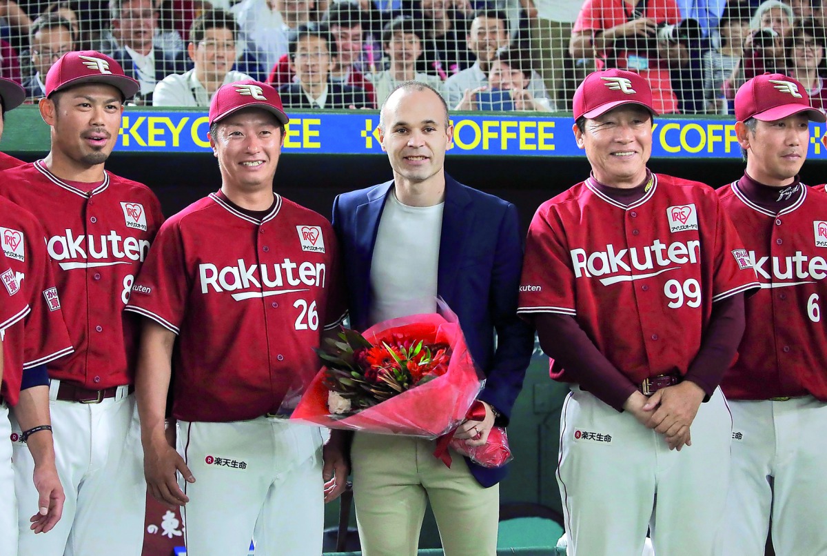 Spain midfielder Andres Iniesta, who signed for Japanese side Vissel Kobe, poses with Japan's professional baseball team Tohoku Rakuten Golden Eagles manager Masataka Nashida and players at Tokyo Dome in Tokyo, Japan, in this photo taken by Kyodo May 24, 