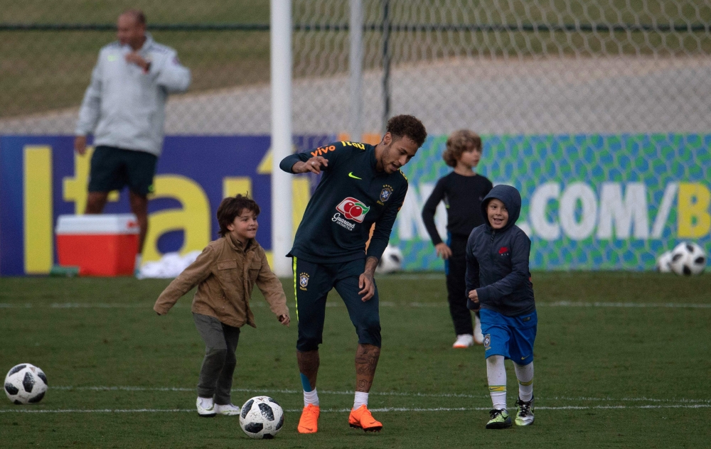 Brazil's player Neymar (C) plays with his son David Lucca (R) and other children after a training session of the national football team ahead of the FIFA 2018 World Cup, at Granja Comary training centre in Teresopolis, Rio de Janeiro, Brazil, on May 25, 2