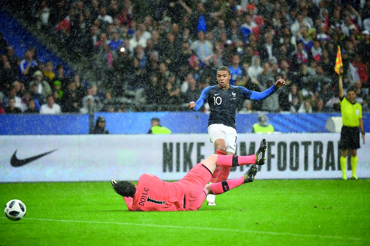 French forward Kylian Mbappe (R) shoots past Irish goalkeeper Colin Doyle during the friendly football match between France and Ireland at the Stade de France stadium, in Saint-Denis, on the outskirts of Paris, on May 28, 2018. The goal was not valid, Fre