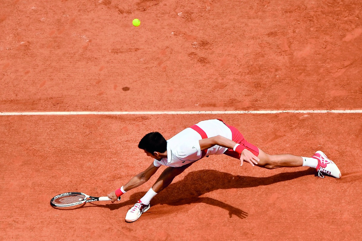 Novak Djokovic plays a backhand return to Spain's Jaume Munar during their men's singles second round match on day four of The Roland Garros 2018 French Open tennis tournament in Paris on May 30, 2018. AFP / Christophe Simon