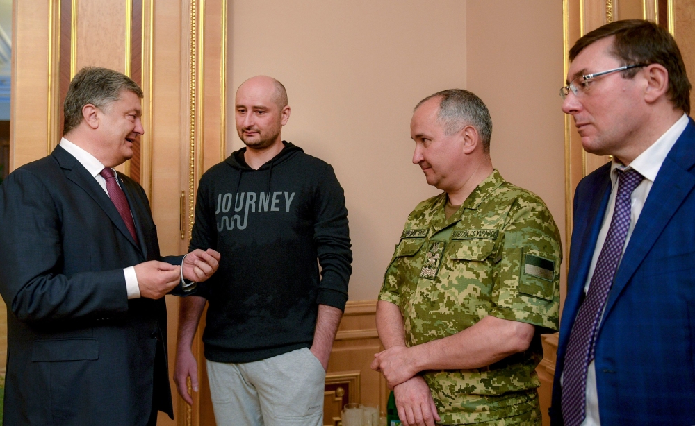 In this handout picture taken and released on May 30, 2018 by the Ukrainian Presidential press service, Ukrainian President Petro Poroshenko (L) speaks with Russian anti-Kremlin journalist Arkady Babchenko (2nd L), head of Ukraine's security service Vasyl