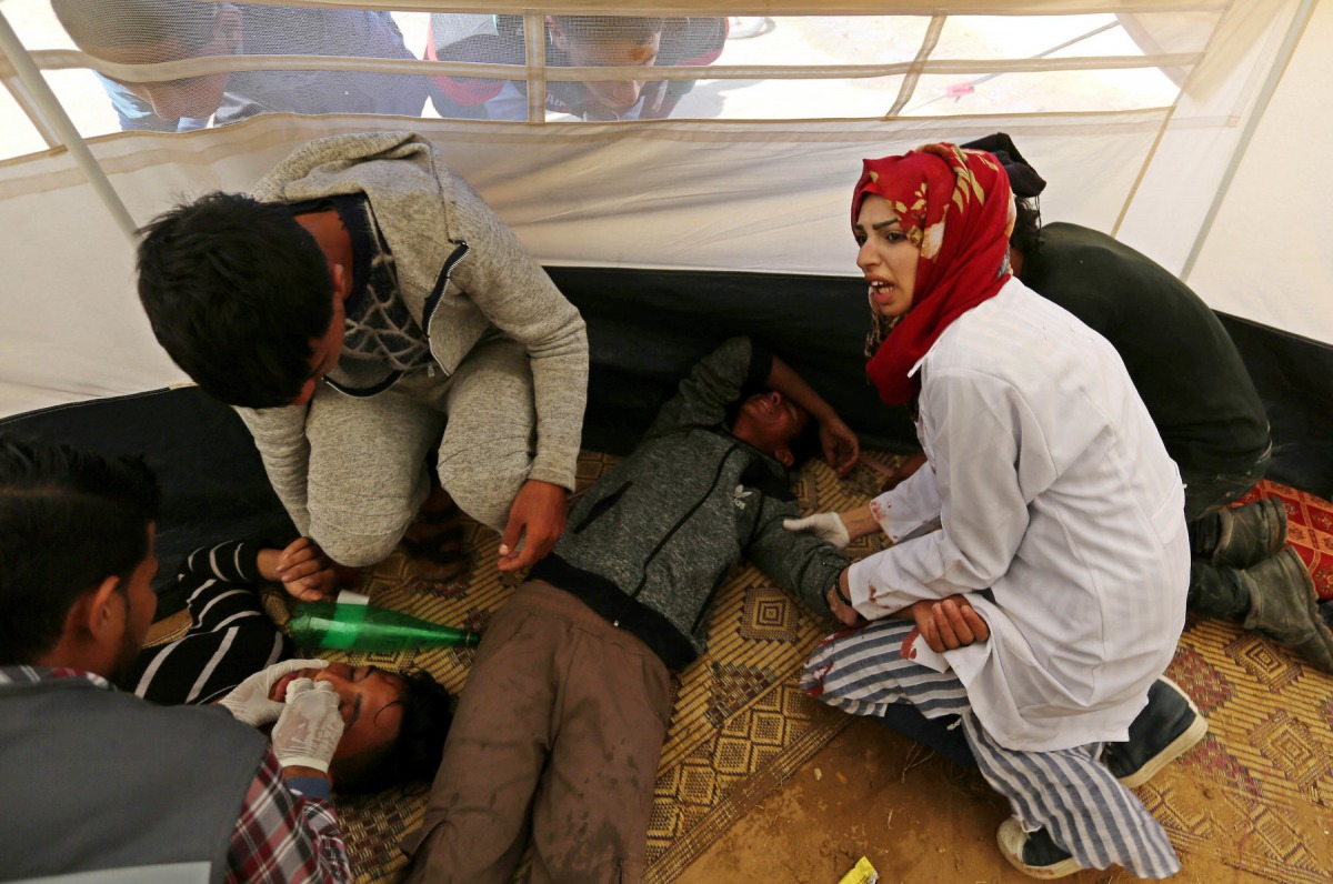 Palestinian nurse Razan al-Najjar helps an injured at an emergency medical tent during protests at the Israel-Gaza border. (Facebook/ The Palestinian Information Center) 