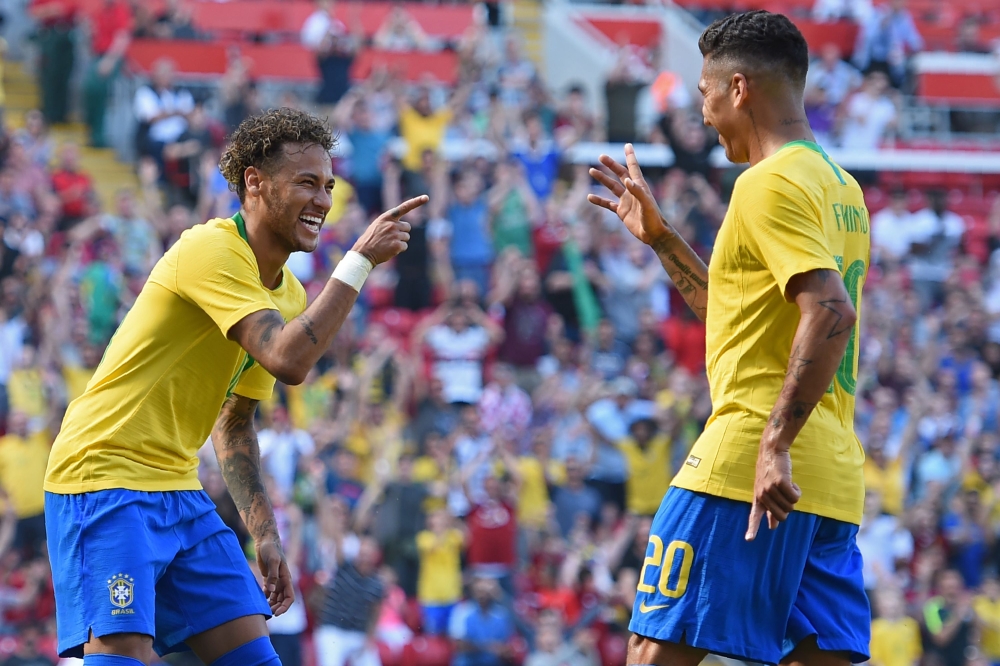 Brazil's striker Roberto Firmino (R) celebrates with Brazil's striker Neymar after scoring their second goal during the International friendly football match between Brazil and Croatia at Anfield in Liverpool on June 3, 2018. Brazil won the game 2-0. (AFP
